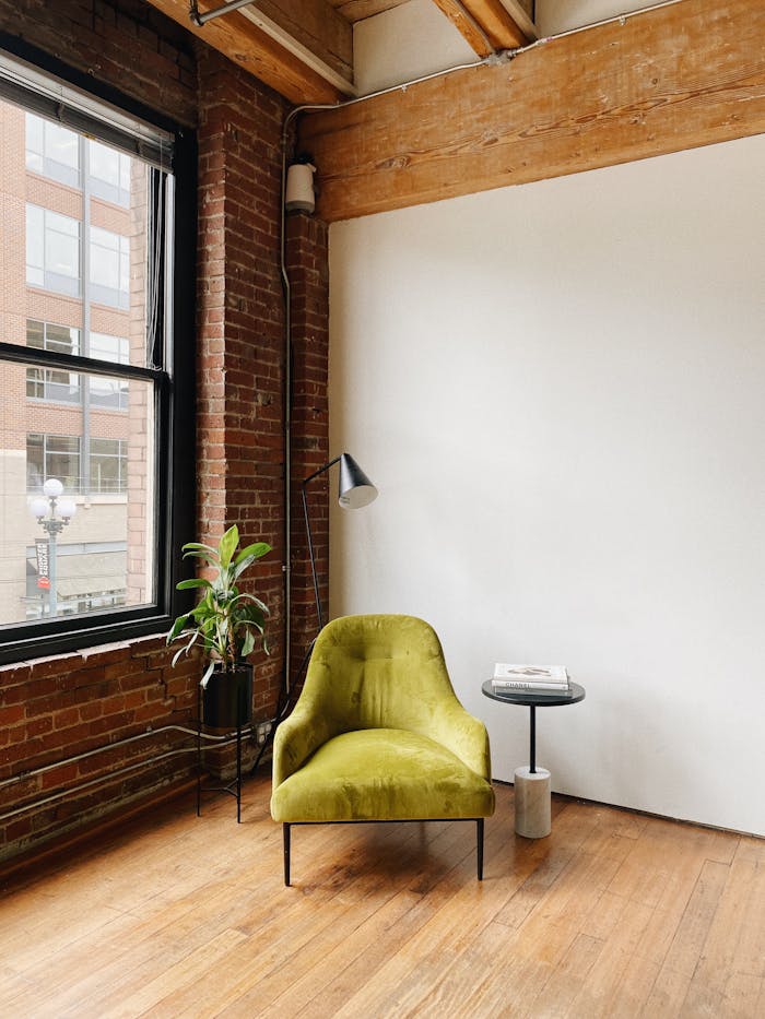 pexels photo 30075354 Modern loft interior with green chair, side table, and plant in Seattle. Cozy and stylish design.